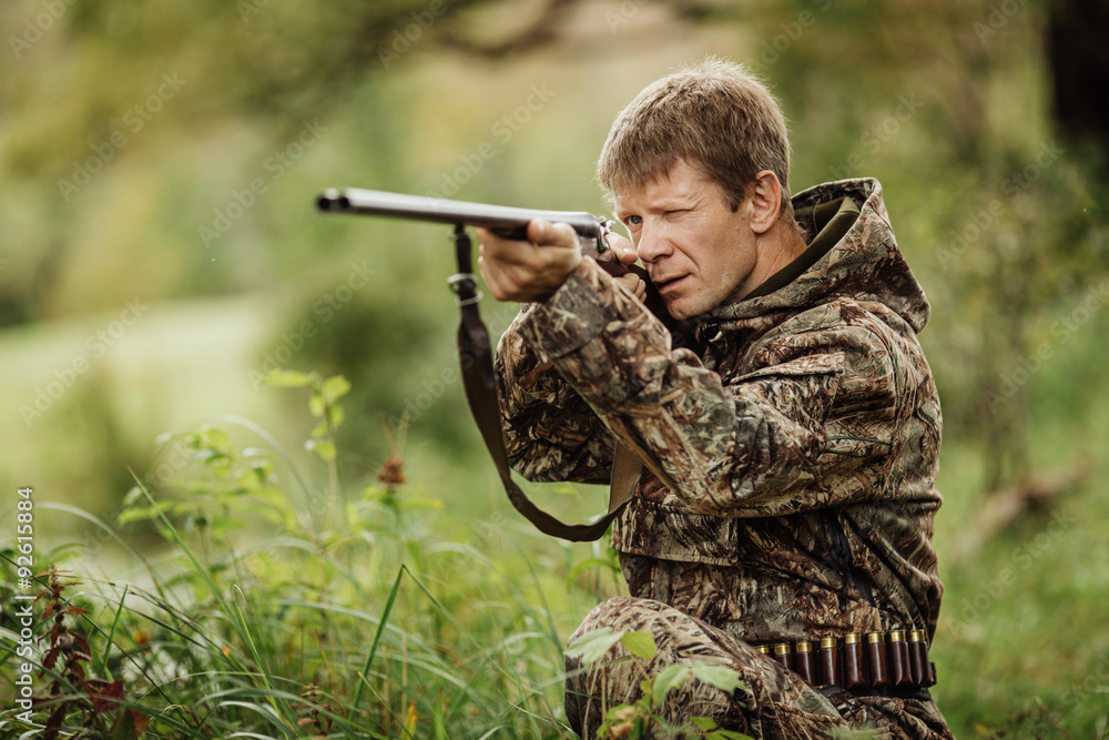Fototapeta premium hunter in camouflage clothes ready to hunt with hunting rifle
