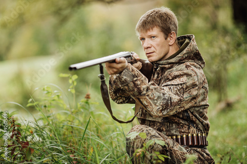 hunter in camouflage clothes ready to hunt with hunting rifle