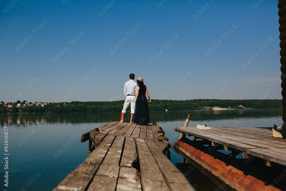 Hugging man and woman in love on wooden pier