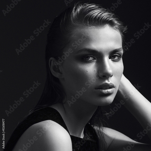 Black and white portrait of a beautiful girl in the studio on a black background, the concept of beauty