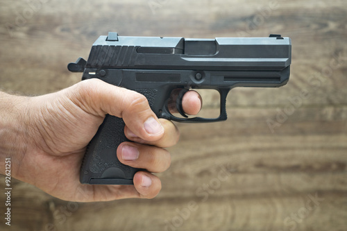 Μasculine hand holding pistol gun