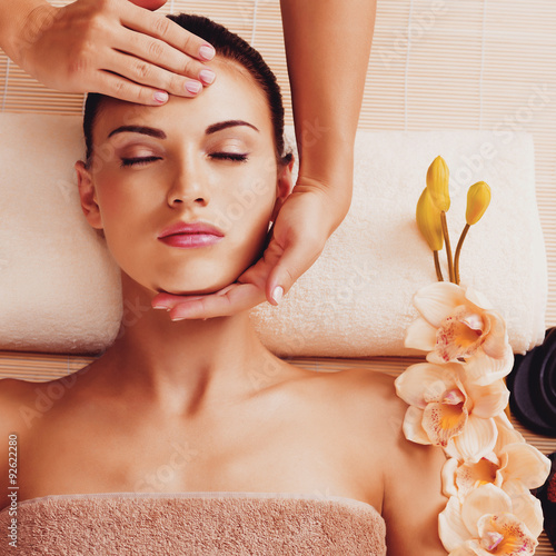 Masażysta robi masaż głowy kobiety w salonie spa
