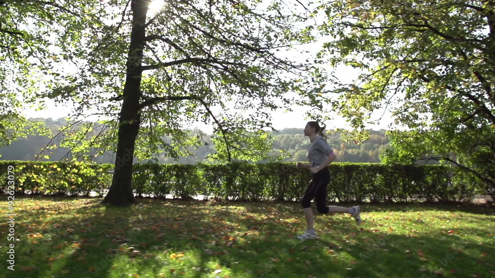 Runner woman running in park exercising outdoors? slow motion Runner woman running in park exercising outdoors? slow motion