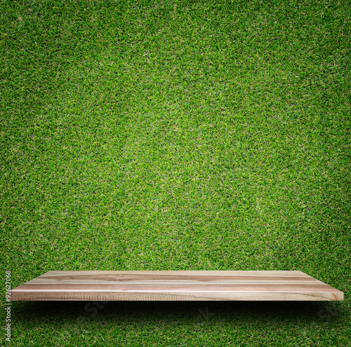 Empty top of wooden shelves and green pattern wall background