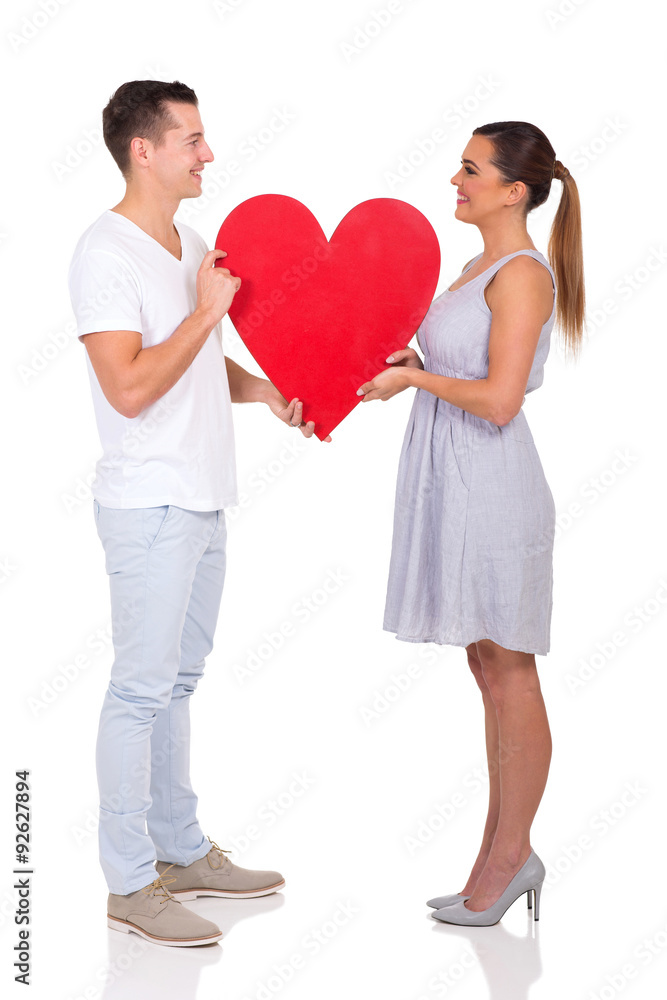 couple holding paper heart symbol - obrazy, fototapety, plakaty 