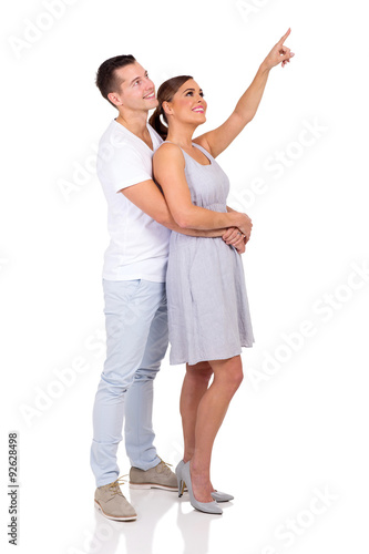 young couple pointing up