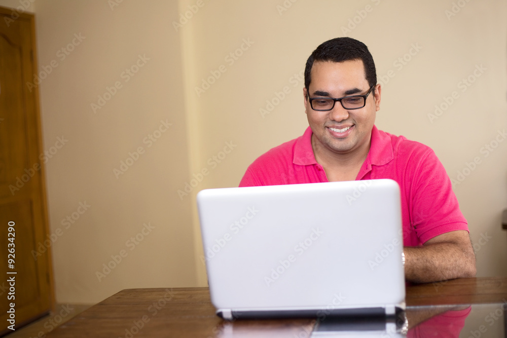 happy young latino man working on a computer happy young latino man working on a computer