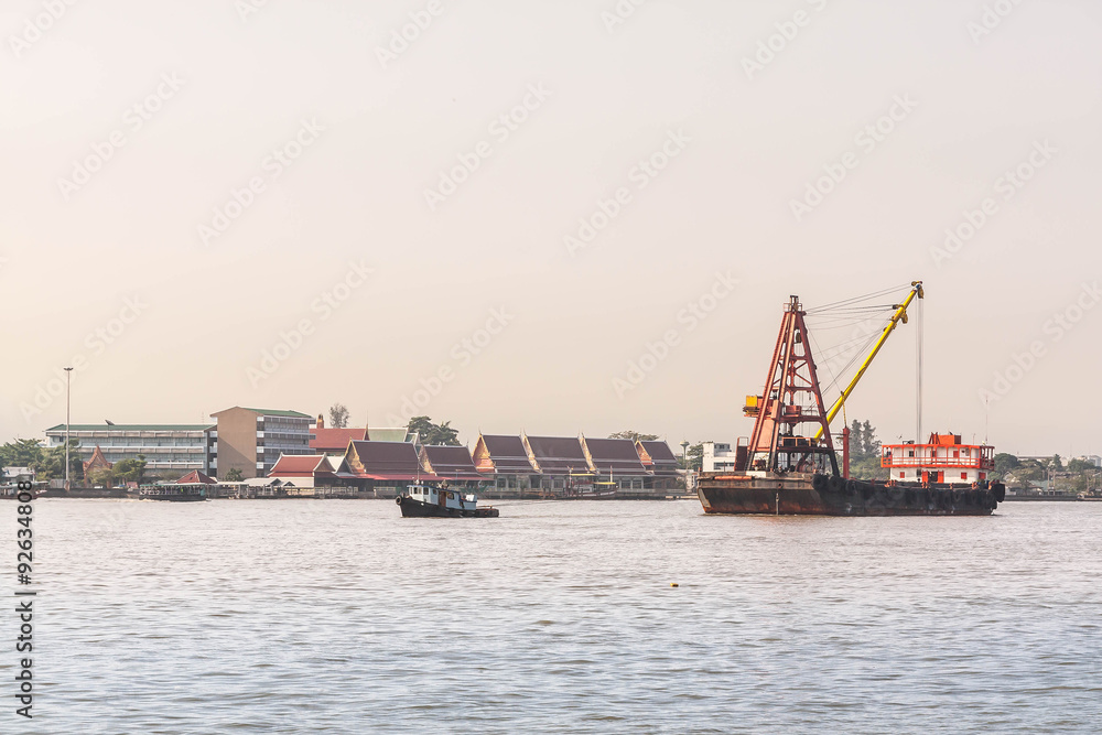 cargo crane ships over river in sunset