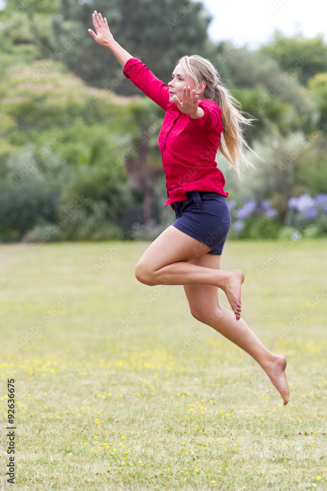 happy 20s woman jumping high with fun in sunny park happy 20s woman jumping high with fun in sunny park