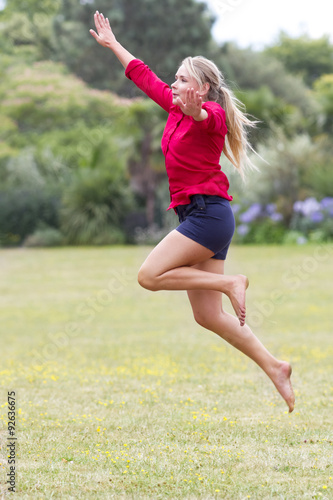 happy 20s woman jumping high with fun in sunny park © STUDIO GRAND WEB