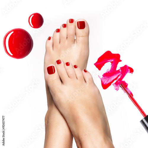 Beautiful female legs with red pedicure and  nail polish