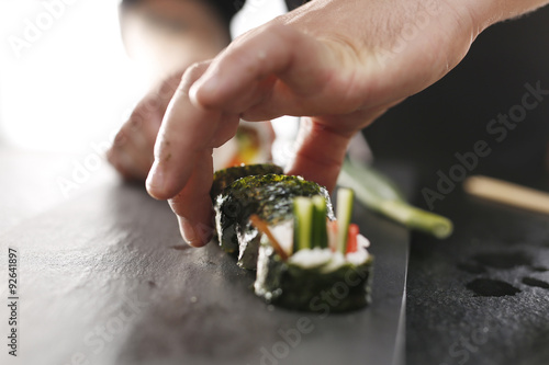 Sushi z łososiem, krewetką i ogórkiem. Klasyczne grube rolki futomaki podane na kamiennym talerzu