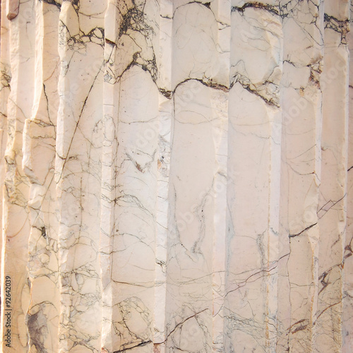Black, grey, And white striated streaks In marble. Close up. Aged photo. Marble column Texture. Close-up structure of a Roman marble column.