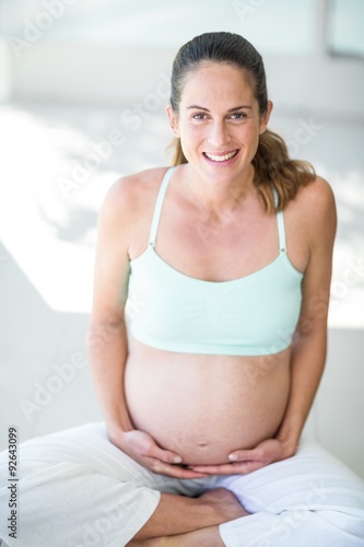 Portrait of happy woman sitting with legs crossed Free Download Portrait of happy woman sitting with legs crossed - GFXLoad