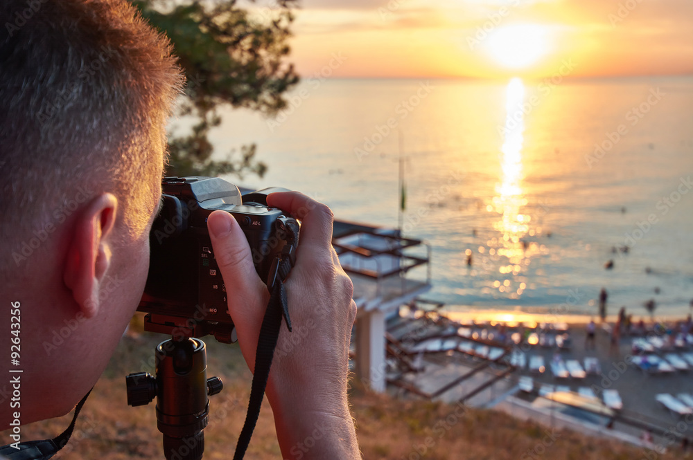 Obraz premium Photographer takes photos of beautiful sunset