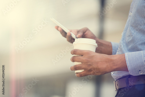 indian business man using phone and coffee in the morning