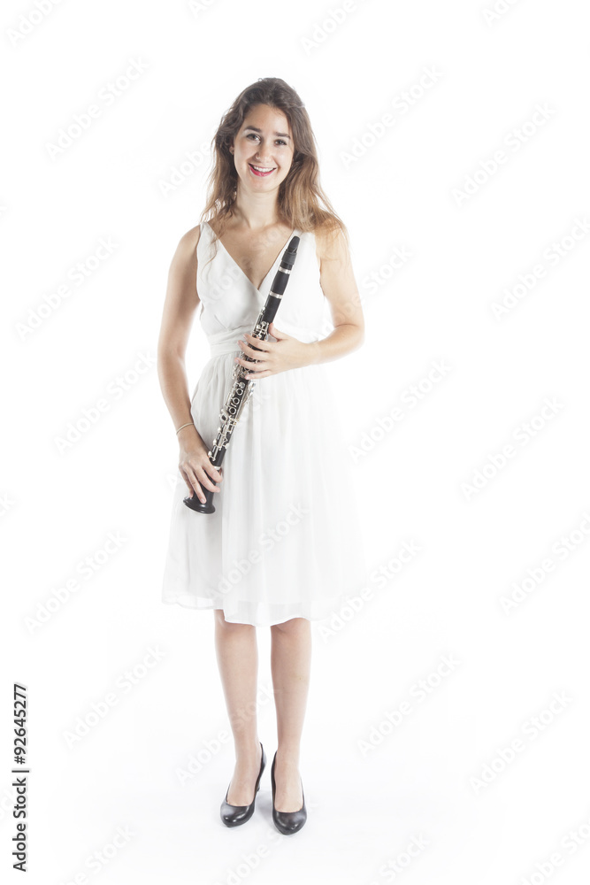 young brunette woman in white dress holds clarinet in studio and young brunette woman in white dress holds clarinet in studio and