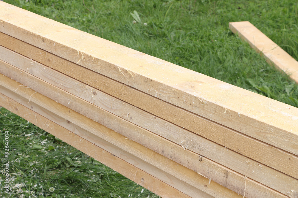 Fresh pine boards against a green grass Fresh pine boards against a green grass