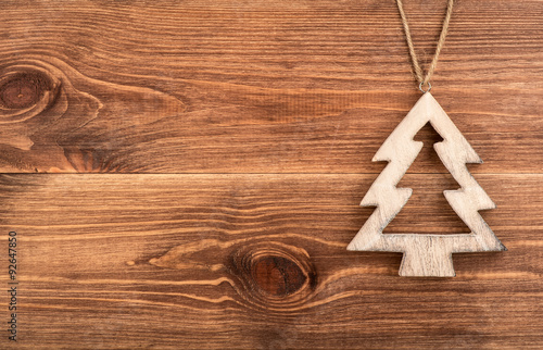 Christmas decorative wooden fir-tree on the wooden background.