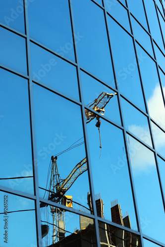 reflection of the sky in the glass windows of the crane construction © alexkich