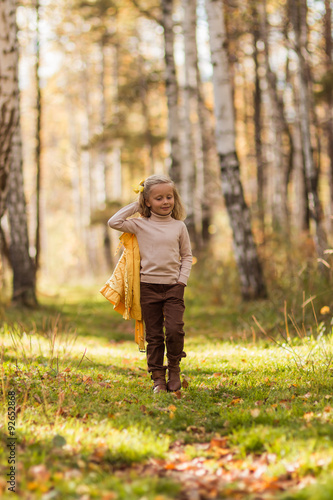 Симпатичная девочка гуляет по осеннему лесу в теплую погоду © viclin