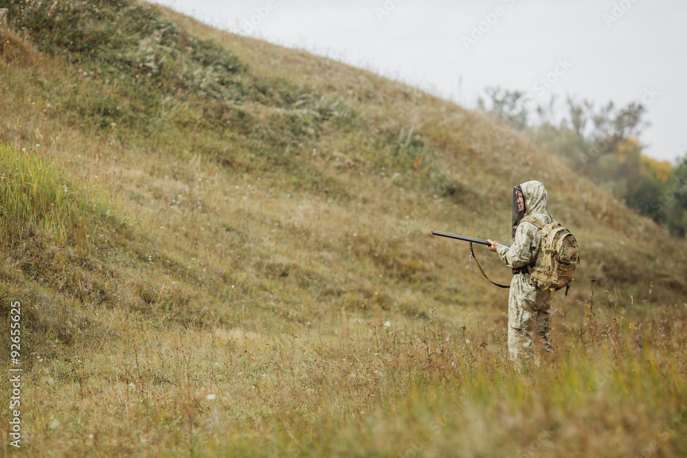 Obraz premium hunter in camouflage clothes ready to hunt with hunting rifle