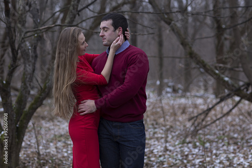 young couple wearing red clothes in winter park