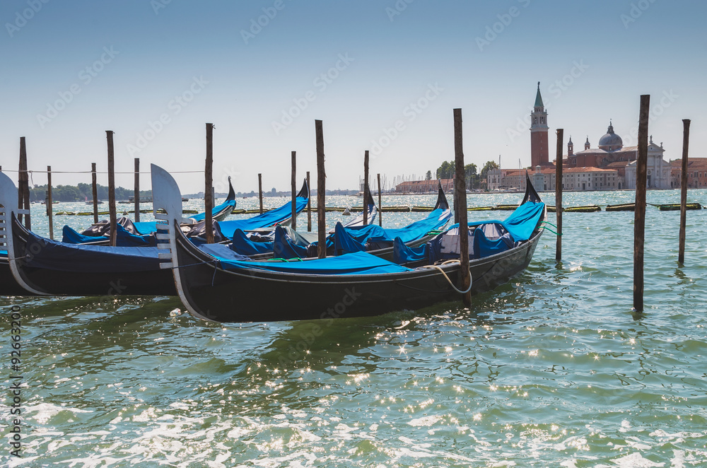 Gondolas docked to the poles on Canal in Venice