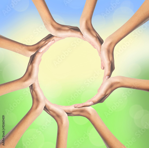 group of young people's hands over bright nature background