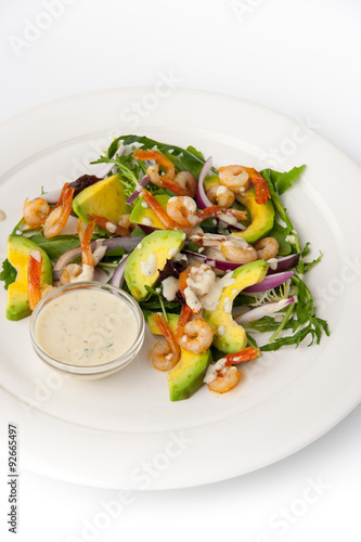 Salad with avocado and shrimp on the white background vertical