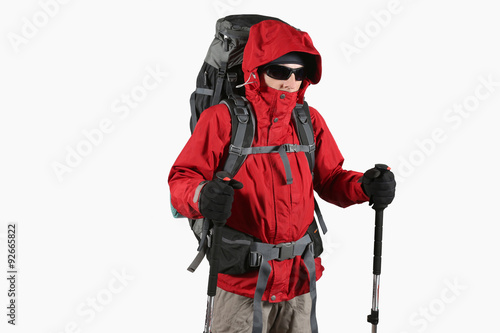 tourist in red jacket with backpack and trekking sticks