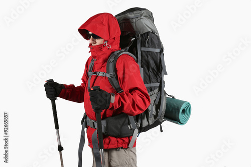 tourist in red jacket with backpack and trekking sticks