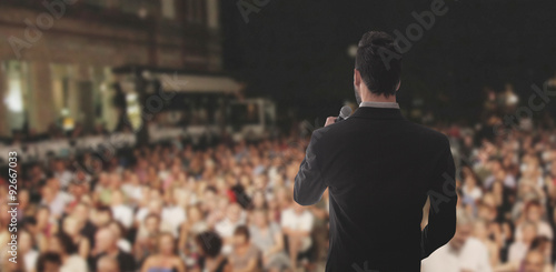 Foto Uomo canta parla sul palco folla