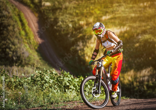 Extreme sports - young woman riding downhill bike