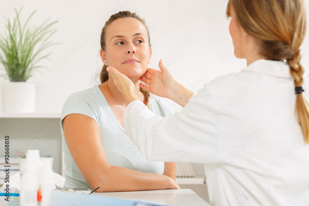 Doctor examining her patients glands at the doctors office Doctor examining her patients glands at the doctors office