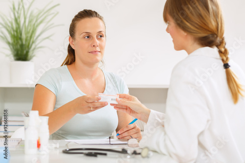 Young woman at the doctors office getting medication and health advice