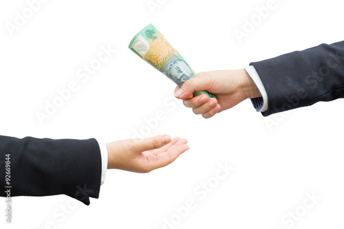 Hands of businessman passing Australian dollar (AUD) banknote on isolated background.
