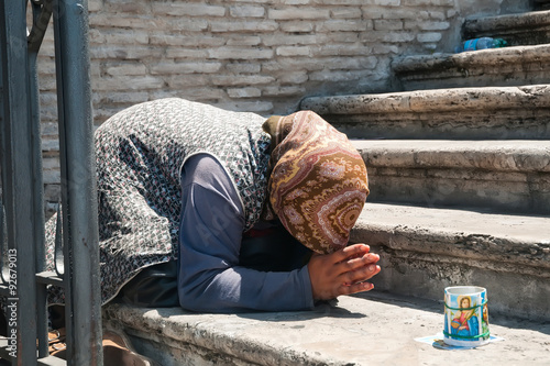 Beggar in Rome - female street beggar in prayer pose