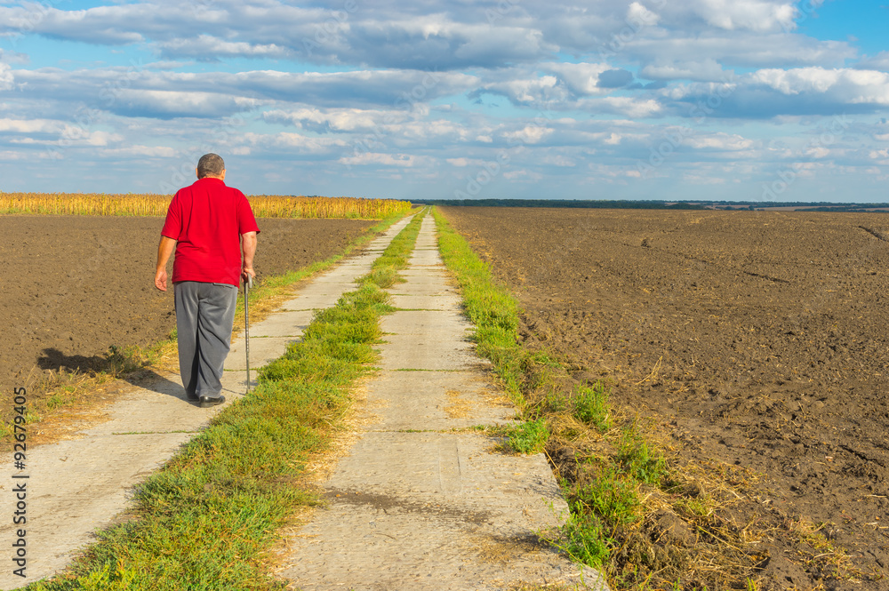 Senior man walking on country concrete road