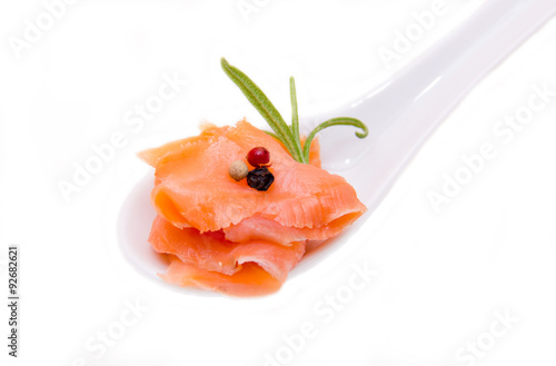 Smoked salmon on spoon on white background seen close