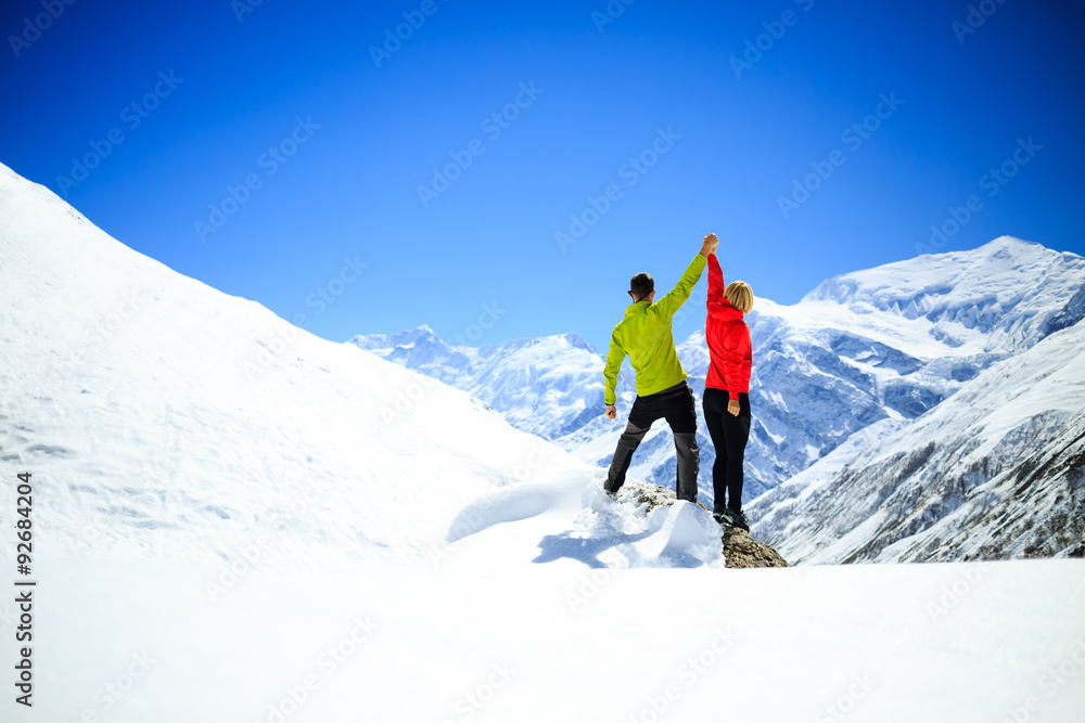 Couple hiking man and woman success in winter mountains