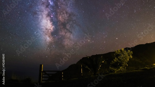 The Milky Way panning over the Island of Sao Miguel, Azores. Distant lights come from the island Santa Maria, more that 100 miles away. photo