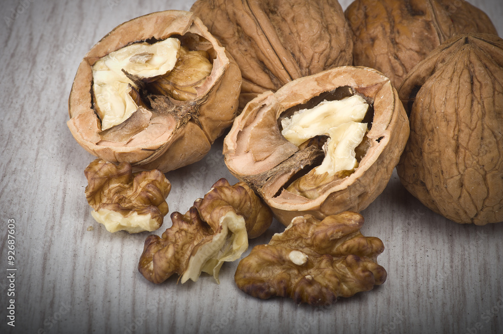 walnuts in shell and open on wood gray table walnuts in shell and open on wood gray table