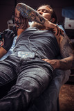 Professional tattooist doing tattoo in salon