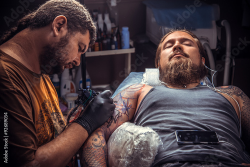 Master showing process of making a tattoo in tattoo studio