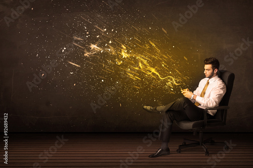 Businessman with tablet and energy explosion on background