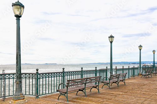 San Francisco Bay wooden pier with benches and light posts. Copy space photo