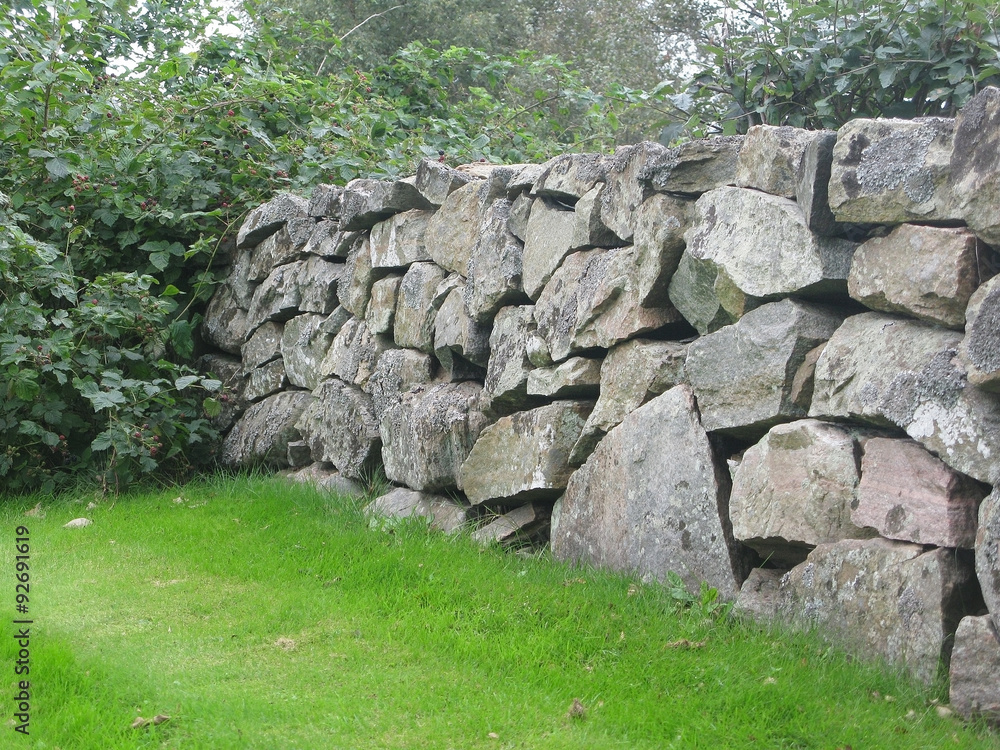 Traditional drystone wall fence as house boundary in Falkenberg, Sweden. Traditional drystone wall fence as house boundary in Falkenberg, Sweden.