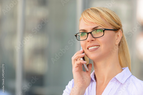 Nice businesswoman standing near office building 