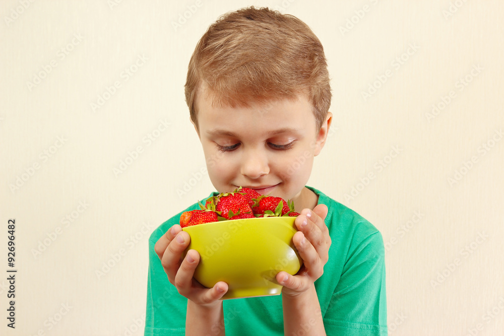 Little boy with a bowl of fresh sweet strawberries Little boy with a bowl of fresh sweet strawberries